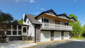 Een herenhuis met balkon, garage en een gevel van natuursteen.