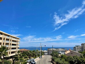 A coastal residential area with buildings, a clear sky, and a view of the sea. - Modern and bright T2, air conditioning, terrace and sea view (Bastia)