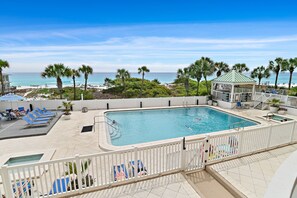 A pool area with a view of the beach, lounge chairs, and a gazebo. - Beachfront & Poolside Luxury at Hidden Dunes (Miramar Beach)