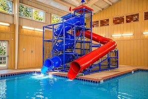 An indoor pool with a multi-level water slide structure. - Glamping | Cozy Smoky Stay | Sleeps 4 - Cub House (Sevierville)