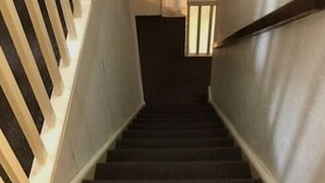 A carpeted staircase with a handrail on the right and a wooden handrail on the left. - The Galloway Hotel  (Blackpool)