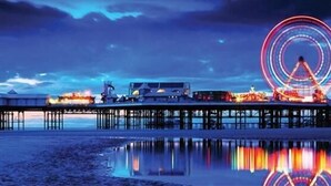 A pier extending into a body of water with a Ferris wheel in the background. - The Galloway Hotel  (Blackpool)