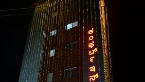 A building with vertical string lights and a sign with text.