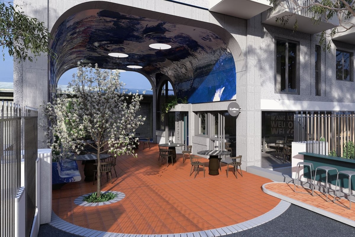 A modern building with a curved roof, outdoor seating area, and a tree with white flowers.