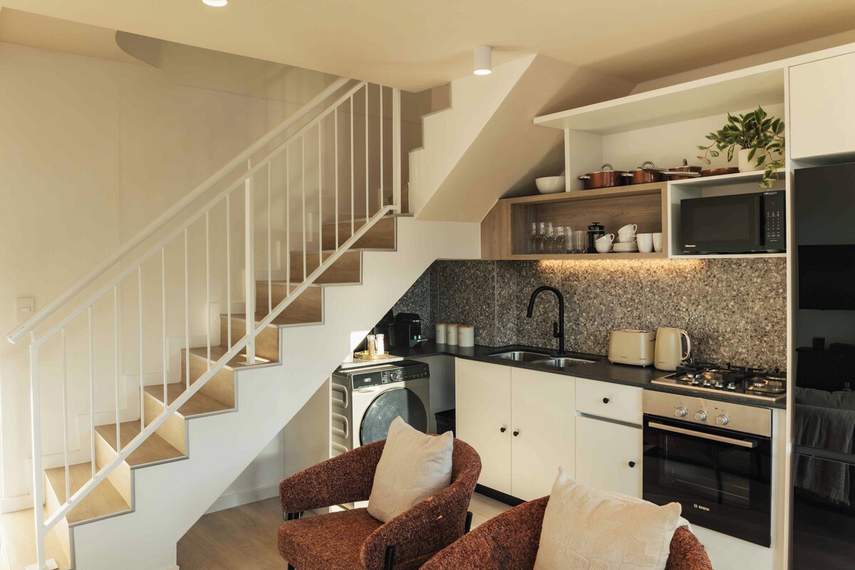 A modern kitchen with a built-in washing machine, a microwave, and a Bosch oven.