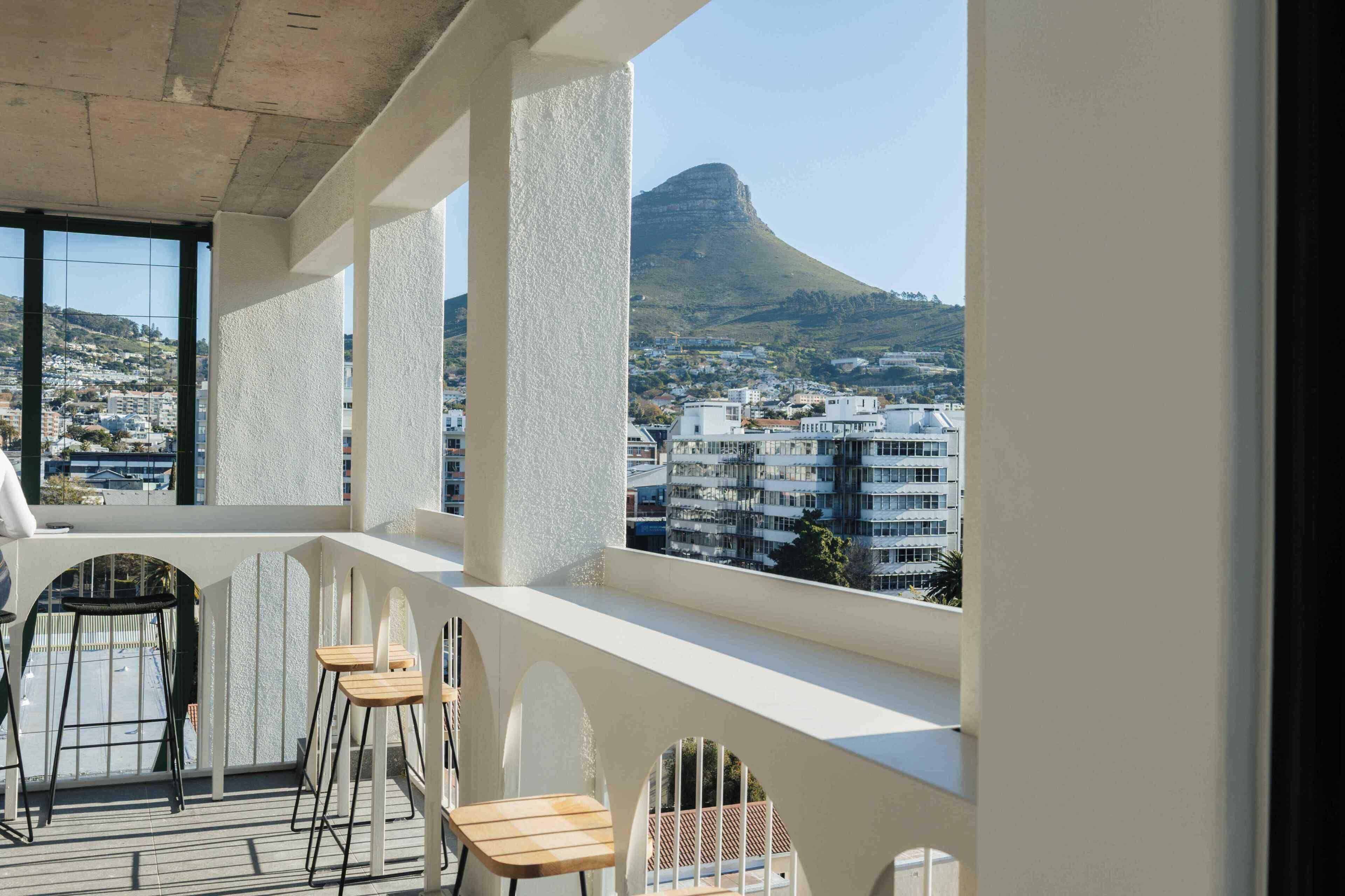 Ein Balkon mit Blick auf einen Berg und Wohnhäuser.