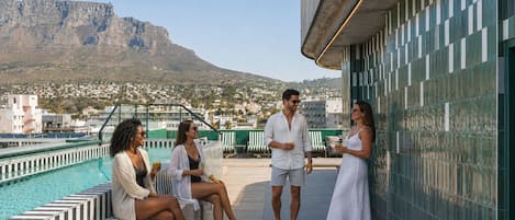 Un espace piscine aménagé sur le toit, offrant une vue sur la montagne et le paysage urbain.