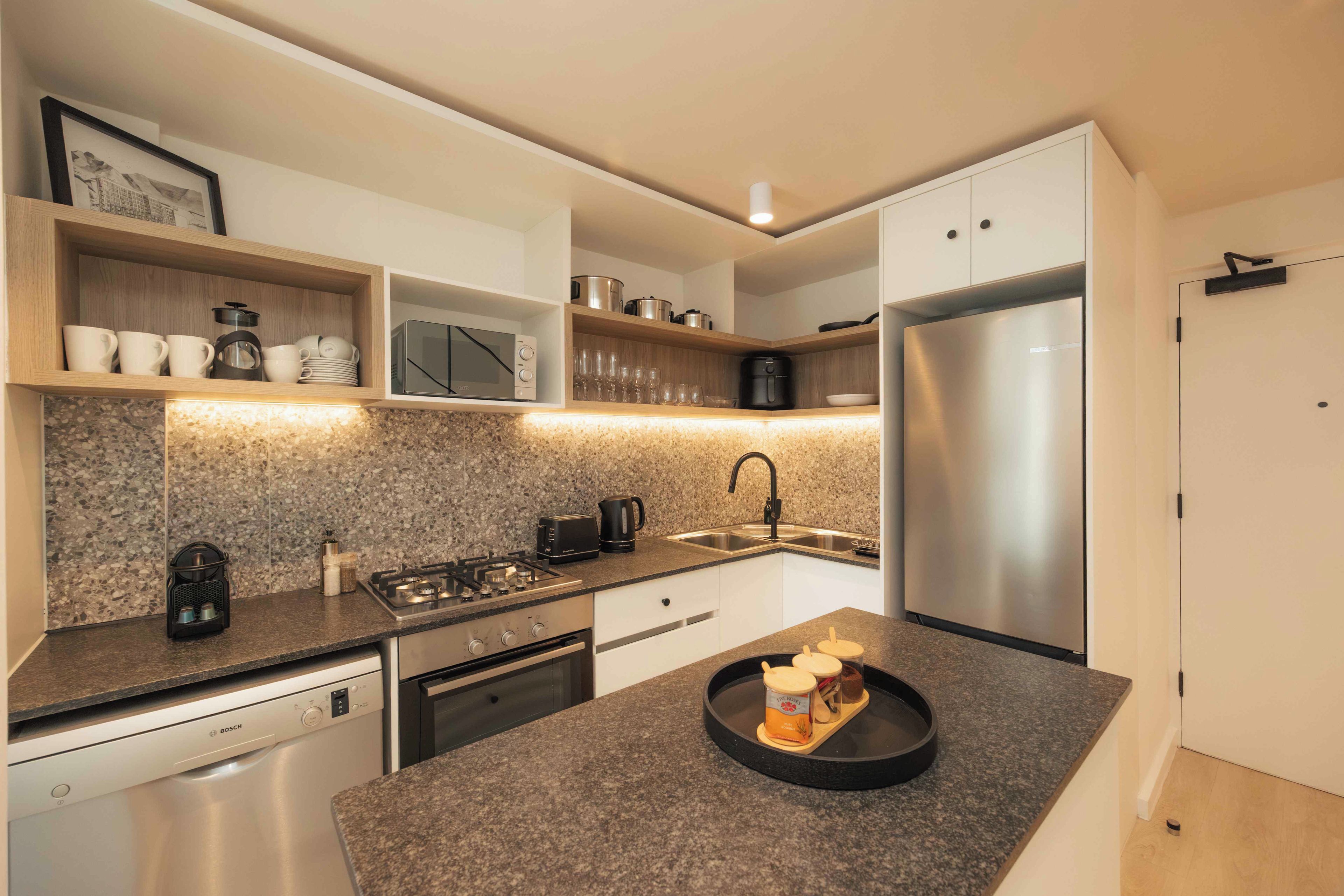 A modern kitchen with a granite countertop, stainless steel appliances, and a built-in oven.