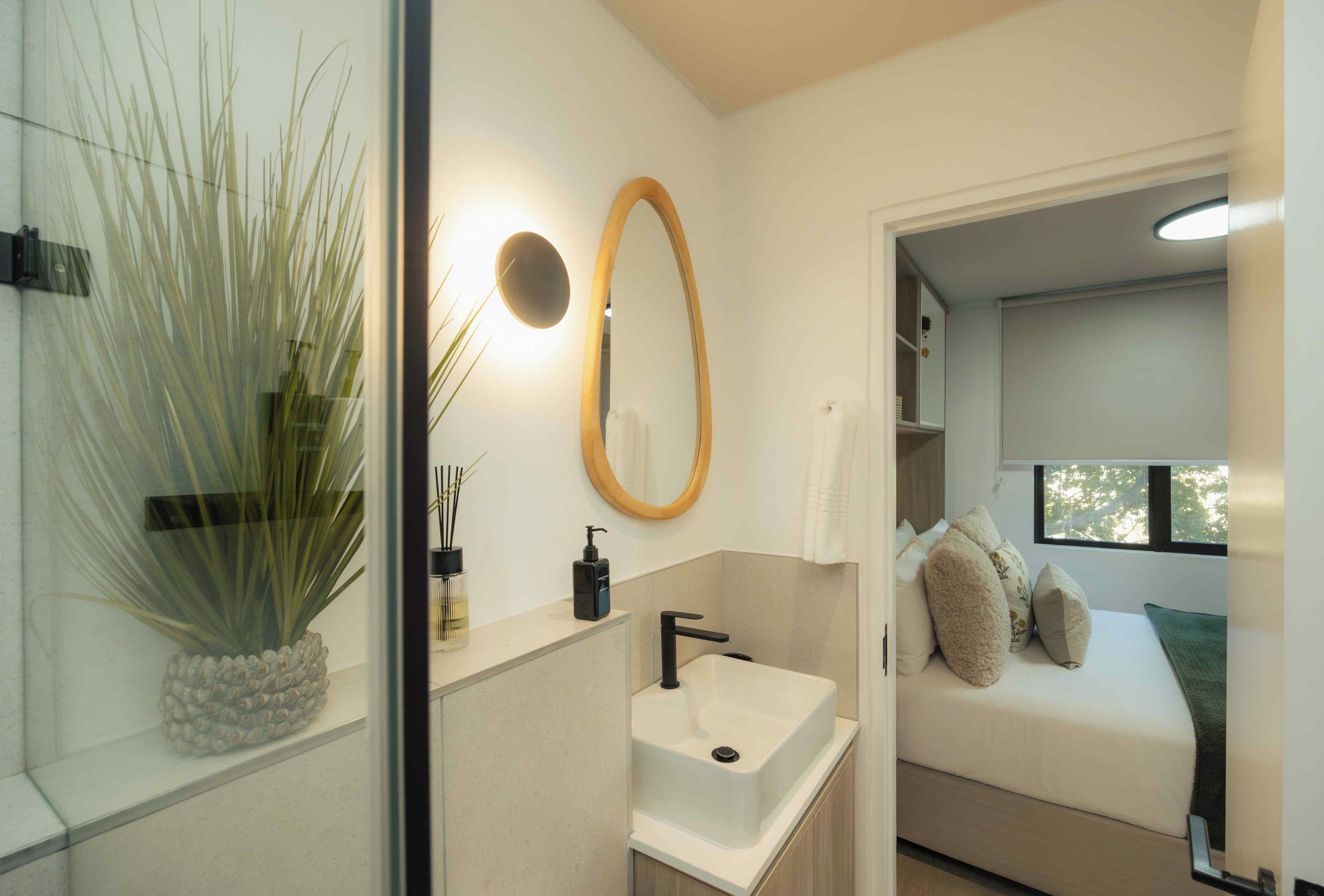 Un bagno moderno con cabina doccia in vetro, lavabo bianco e specchio.