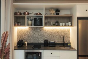 Een moderne keuken met inbouwapparatuur, een granieten werkblad en een roestvrijstalen koelkast.