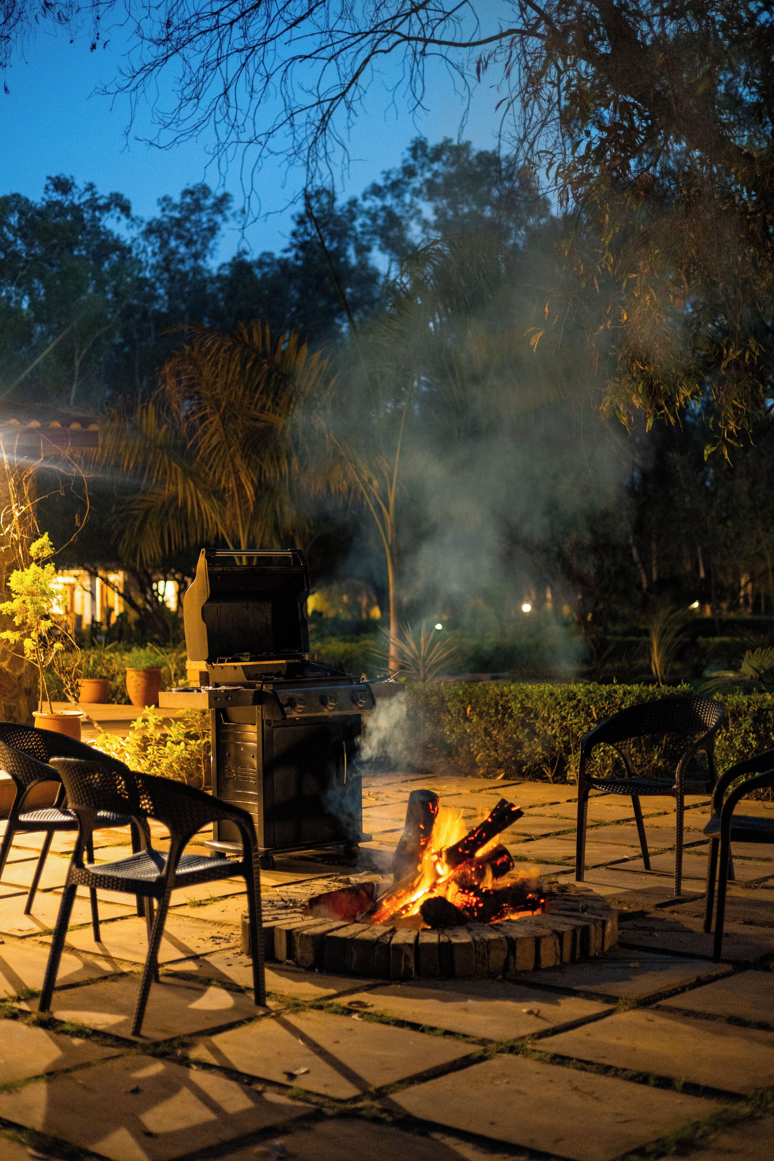 Une terrasse extérieure équipée d’un barbecue, d’un foyer et de deux chaises.