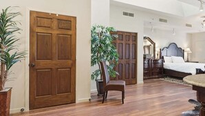 A bedroom with a bed, bedside tables, a chair, a desk, and a large window. - 391 Edgewater | Downtown Charlevoix | Pool, Hot Tub, Sauna | Full Kitchen (Charlevoix)