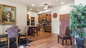A dining area with patterned chairs, a table, and a painting on the wall. - 391 Edgewater | Downtown Charlevoix | Pool, Hot Tub, Sauna | Full Kitchen (Charlevoix)