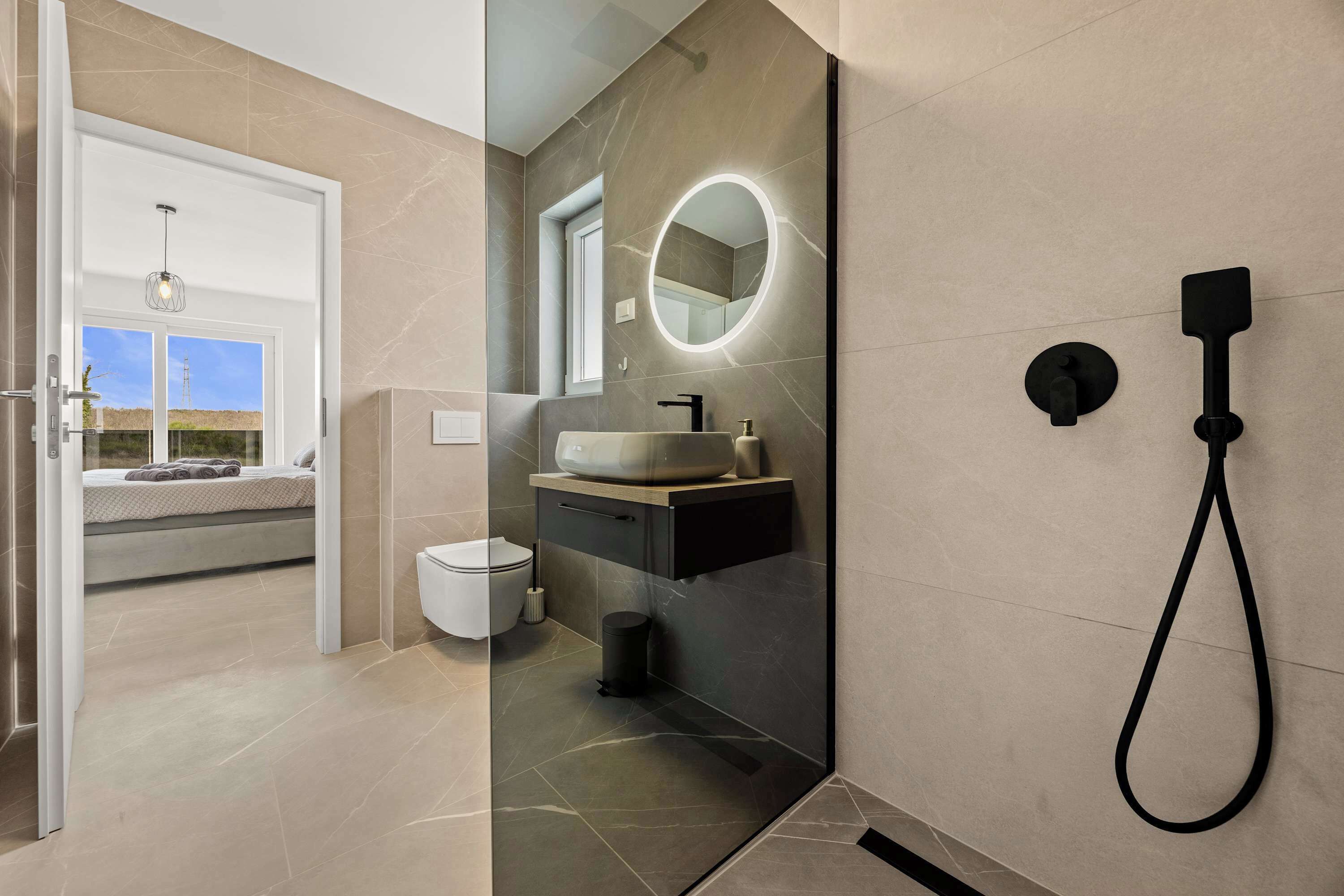 Een moderne badkamer met een grote spiegel, een wastafel en een douche.