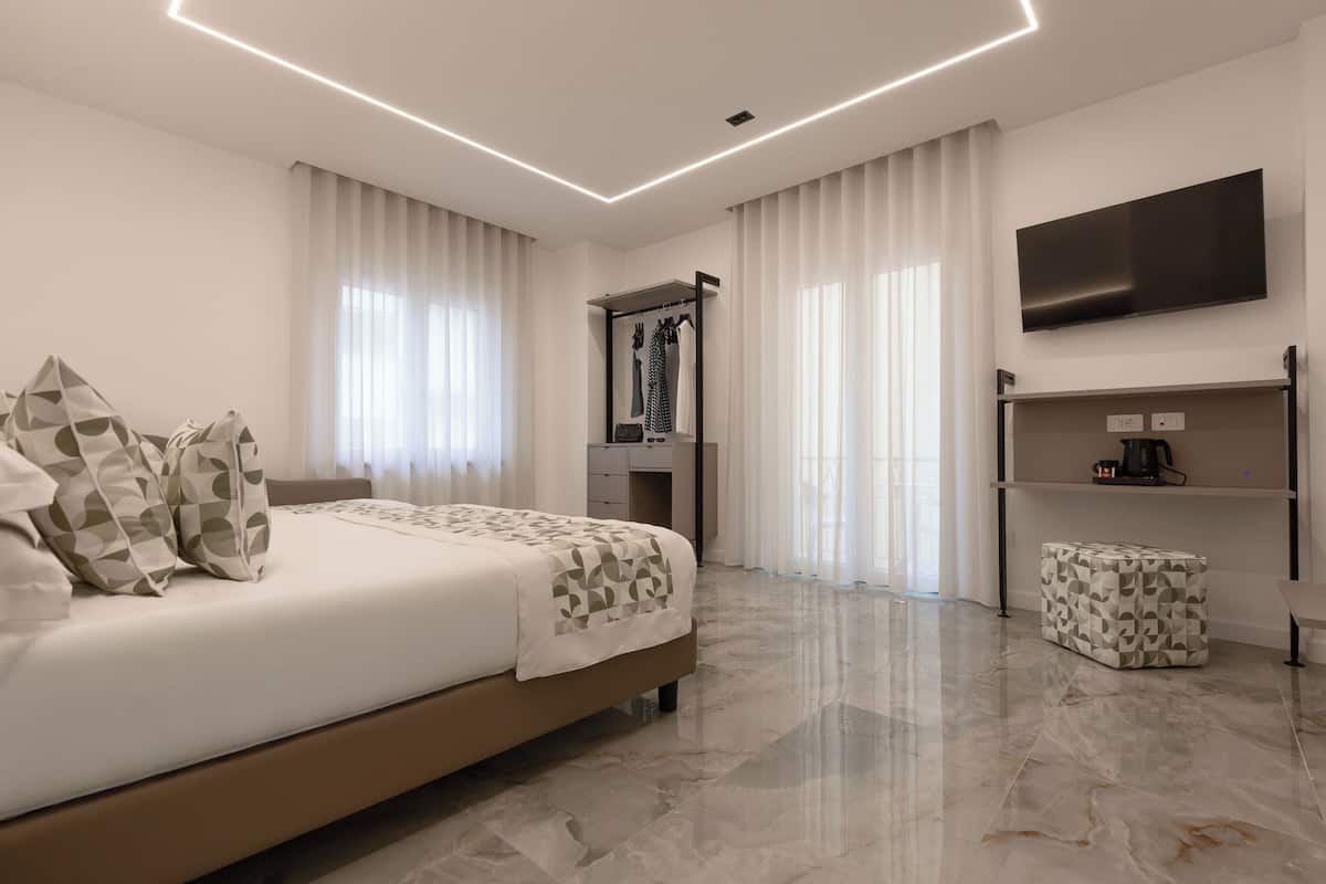 Une chambre d’hôtel moderne équipée d’un lit, d’une télévision, d’un bureau et d’une armoire.
