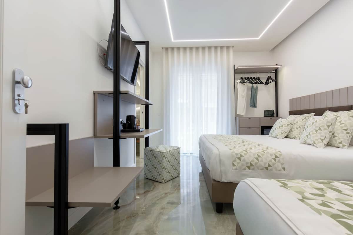 Une chambre d’hôtel moderne équipée d’un lit, d’un bureau, d’une télévision et d’une armoire.