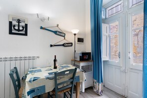 Ein Essbereich mit einem Tisch für zwei Personen, einer Weinflasche und einer Lampe.