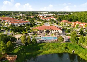 A residential area with multiple houses, a swimming pool, and a small body of water. - Upstay Lakefront Home w Pool Cinema Games BBQ (Kissimmee)