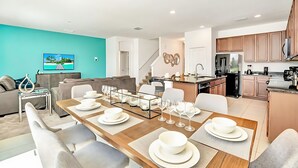 A modern living room with a dining area, kitchen, and a staircase. - Upstay Lakefront Home w Pool Cinema Games BBQ (Kissimmee)