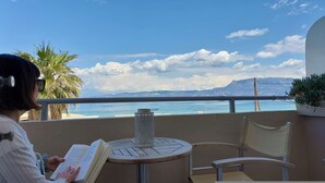A balcony with a view of the sea, a table with a book, and a chair. - Tsiamis Sea Sun - Cozy and Stylish Nest (Corinth)