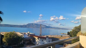 A coastal view with a clear sky, a body of water, and distant mountains. - Tsiamis Sea Sun - Quaint and Homely Getaway (Corinth)