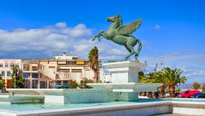 A statue of a winged horse on a pedestal in a public square with buildings in the background. - Tsiamis Sea Sun - Quaint and Homely Getaway (Corinth)