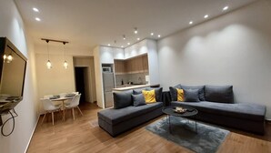 Uma sala de estar moderna com sofá, mesa de jantar e área de cozinha.