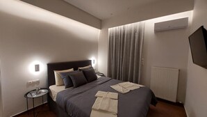 Quarto de hotel moderno com cama, mesa de cabeceira e vista para o exterior.