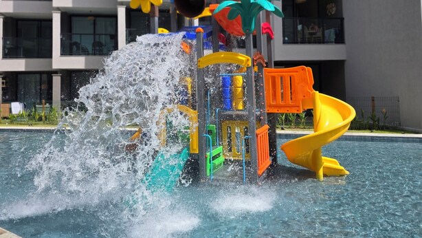 Un espace de jeux aquatiques avec un toboggan et une fontaine.