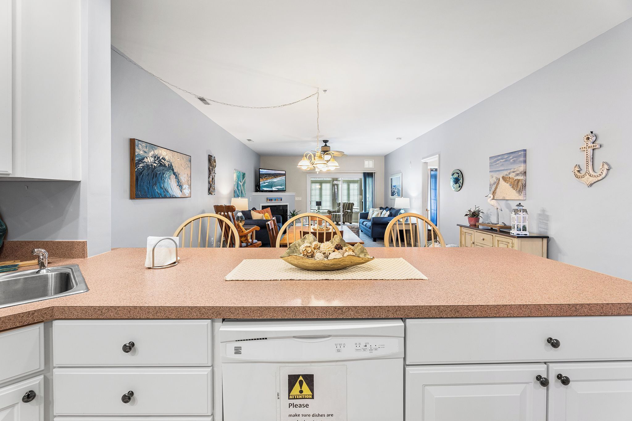 Una cocina moderna con encimera de granito, armarios blancos y un comedor con mesa y sillas.
