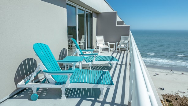 A balcony with chairs and tables, overlooking the ocean. - 1815 North Hampton, Ocean View Condo With Full Access!! 3 Bedroom Condo (Myrtle Beach)