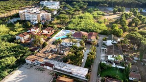 An aerial view of a coastal residential area with buildings, a swimming pool, and a beach. - Marina Living Rooms – Economy Double Room with Shared Pool, Wi-Fi & Air Conditioning (Laura)
