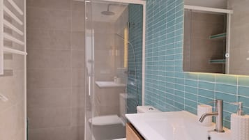 Een douche, handdoeken, zeep, toiletpapier