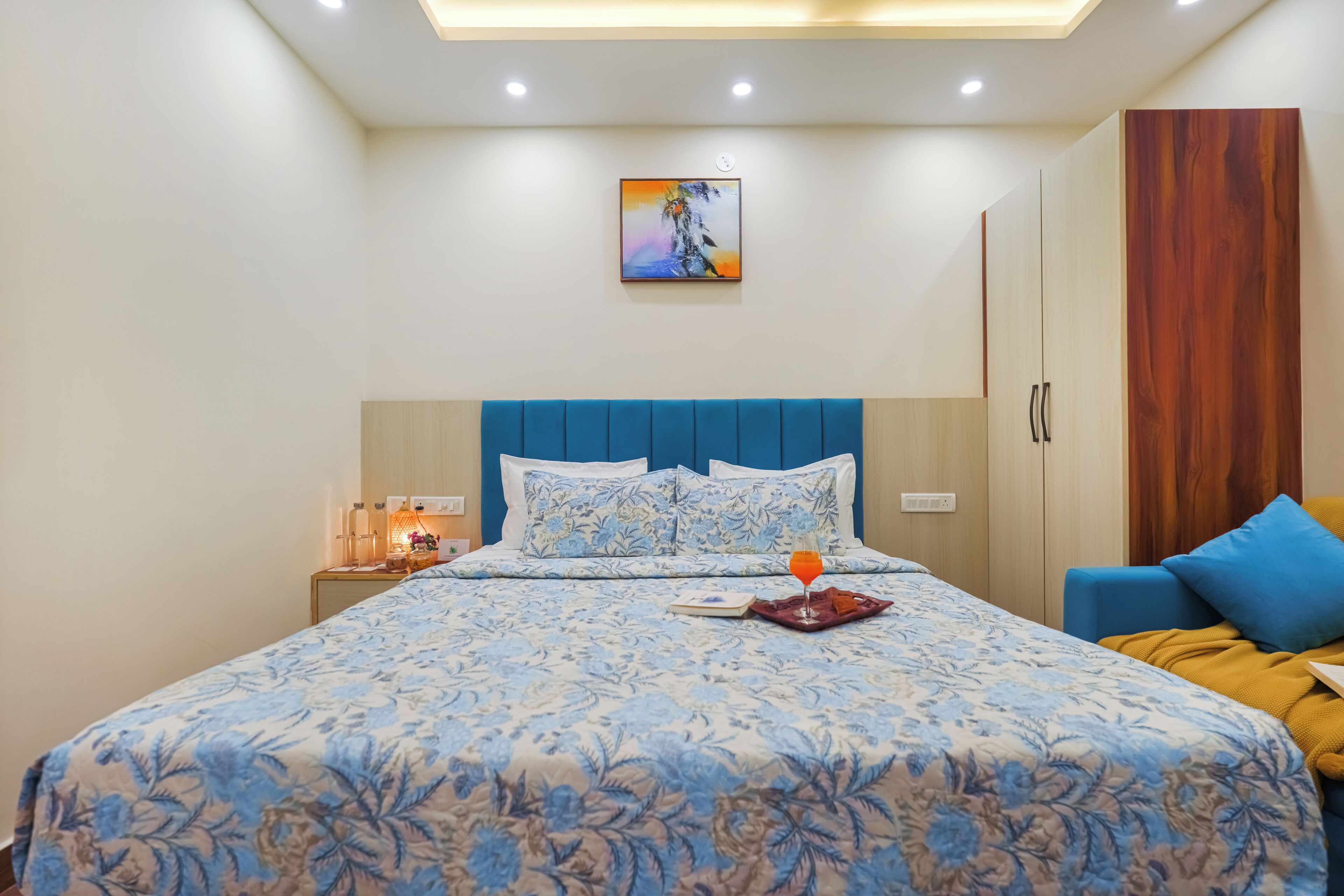 Una camera da letto con un letto, un comodino, un armadio e un quadro appeso al muro.