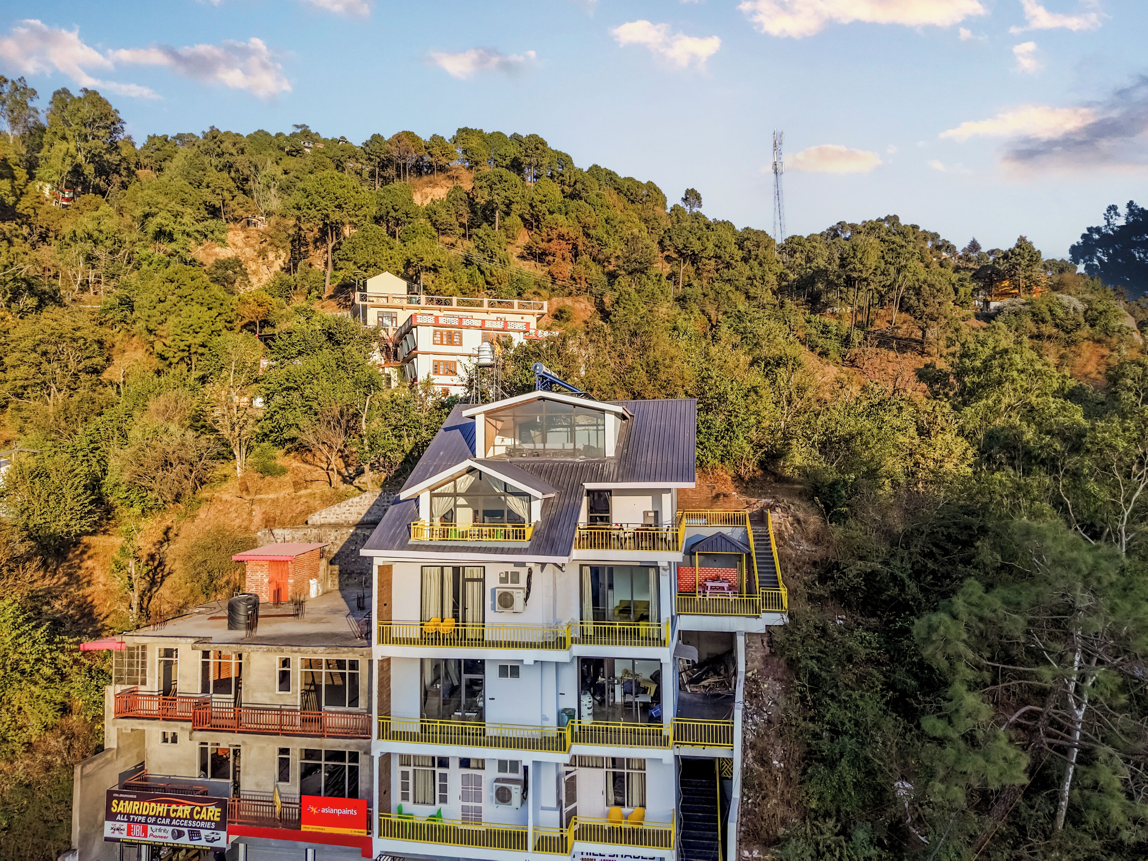 A multi-story building with balconies and a sign for Samriddhi Car Care.