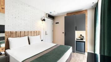 Ein Hotelzimmer mit Bett, Schreibtisch, Kleiderschrank und einer Küchenzeile.