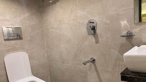 Un baño moderno con inodoro, ducha y lavamanos.
