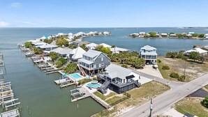 A coastal residential area with houses, docks, and a large body of water. - Boat Friendly Canal Retreat | Private Pool + Private Pier (Dauphin Island)