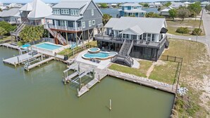 A waterfront property with multiple buildings, docks, and swimming pools. - Boat Friendly Canal Retreat | Private Pool + Private Pier (Dauphin Island)