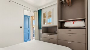 A bedroom with a bed, a wardrobe, and a door leading to an outdoor area. - Air-conditioned Apartment with Pool and Tennis in Les Restanques, Grimaud (Grimaud)