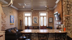 A kitchen with a central island, brick walls, and pendant lighting.