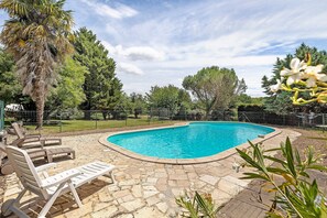 A swimming pool with lounge chairs, surrounded by stone tiles and greenery. - Welcome to "Gite la Loge" in St Aignan (Saint-Aignan)