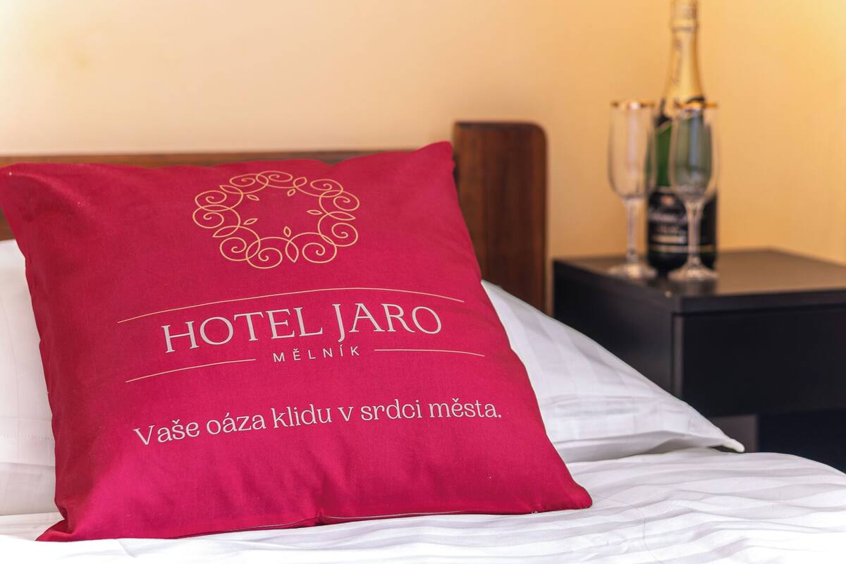 Ein Hotelkissen mit der Aufschrift 'HOTEL JARO' und einer Schrift in einer Fremdsprache.