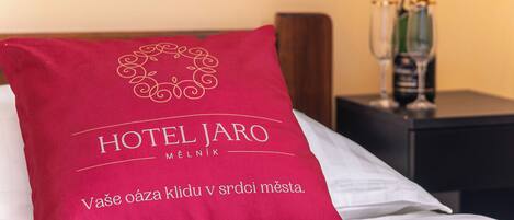 Almohada de hotel con la inscripción 'HOTEL JARO' y un mensaje en un idioma extranjero.