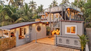 Una casa de varios niveles con balcón, área de cocina y pared decorativa.