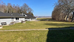 Ein Gebäude mit flachem Dach, einer überdachten Veranda und einem Rasen.