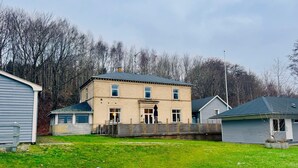 Ein zweistöckiges Haus mit Veranda, Garage und kleinem Garten.