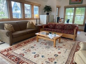 Un salon avec deux canapés, une table basse et un tapis à motifs.