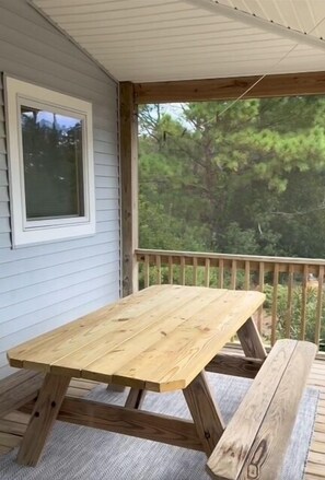 A wooden deck with a picnic table and bench, surrounded by a wooden railing. - Sialang- Private Waterfront Pier, Hot Tub, Kayaks (Chincoteague Island)