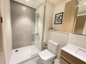 A modern bathroom with a glass-enclosed shower, a white toilet, and a wooden vanity with a sink. - 2 BR Sapphire 405 in Marassi North Coast (El Alamein)